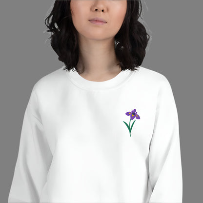 Image: A beautifully embroidered iris flower crewneck sweatshirt in a soft, relaxed fit. This custom floral design adds an elegant touch to any wardrobe, making it a meaningful Mother's Day gift or a thoughtful present for nature lovers. The intricate embroidery captures the essence of the bearded iris, creating a timeless piece that celebrates botanical beauty and personal style, by jaecrece.