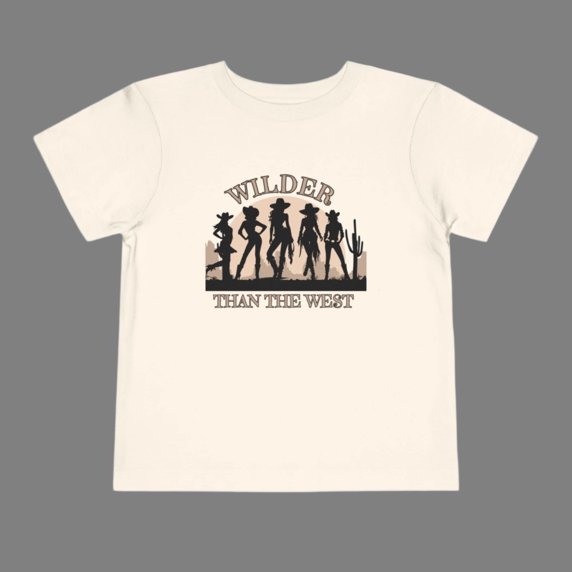 Wilder than the West toddler tee with a bold cowgirl graphic is perfect for girls who love rodeo rides and dusty trails. Designed in soft natural, this western silhouette shirt for toddlers pairs effortlessly in mama mini sets for festivals, birthdays, or Texas fair events. A comfy toddler country girl shirt with vintage vibes and a strong western quote—great for southern babes and little cowgirls in training.