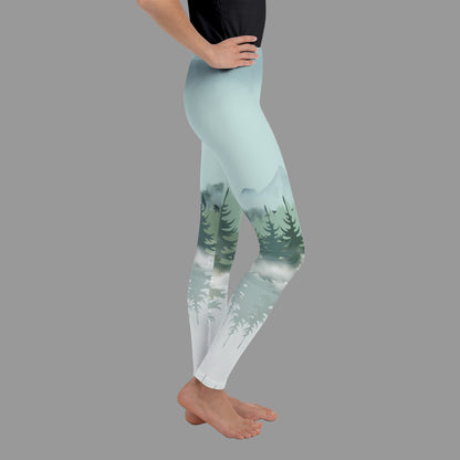 Kids Winter Forest Leggings with snowy mountain and pine tree design, available in youth sizes 8–20. Part of a family matching collection, perfect for ski lodge vacations, winter trips, après-ski lounging, outdoor adventures, and family holiday photos. Soft, stretchy microfiber yarn stretches both ways for comfort and durability. Eco-friendly, made-to-order leggings designed to keep kids stylish and coordinated with the whole family.