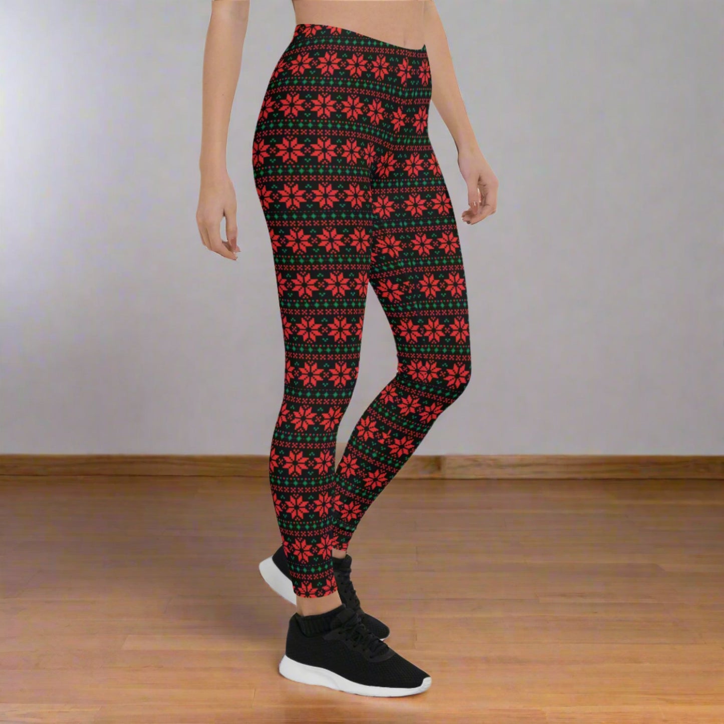 Holiday leggings for women with a black base and red and green poinsettia print in a fair isle geometric aesthetic. Designed with a mid rise waist and full length to the ankle, these leggings are soft, stretchy, and perfect for Christmas outfits, cozy winter days, and festive events. A great choice for matching family outfits, mommy and me style, and shoppers searching for cute Christmas leggings.
