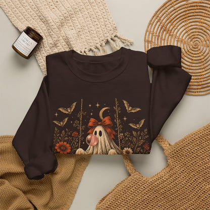 Women's vintage Halloween crewneck sweatshirt featuring a playful ghost on a swing blowing bubble gum. The detailed design combines floral and botanical elements with bats, lace, stars and a crescent moon for a whimsical spooky fall aesthetic.