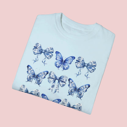 Image: Elegant women’s tee featuring butterflies, blue toile bows, and delicate detailing, capturing both French aesthetic and soft girl charm. Perfect for bougie mamas and cottagecore lovers, this top is designed for comfort and flair. As part of a matching family collection, you can coordinate with toddler and youth sizes for effortlessly stylish family looks during spring outings or photo shoots, by jaecrece.