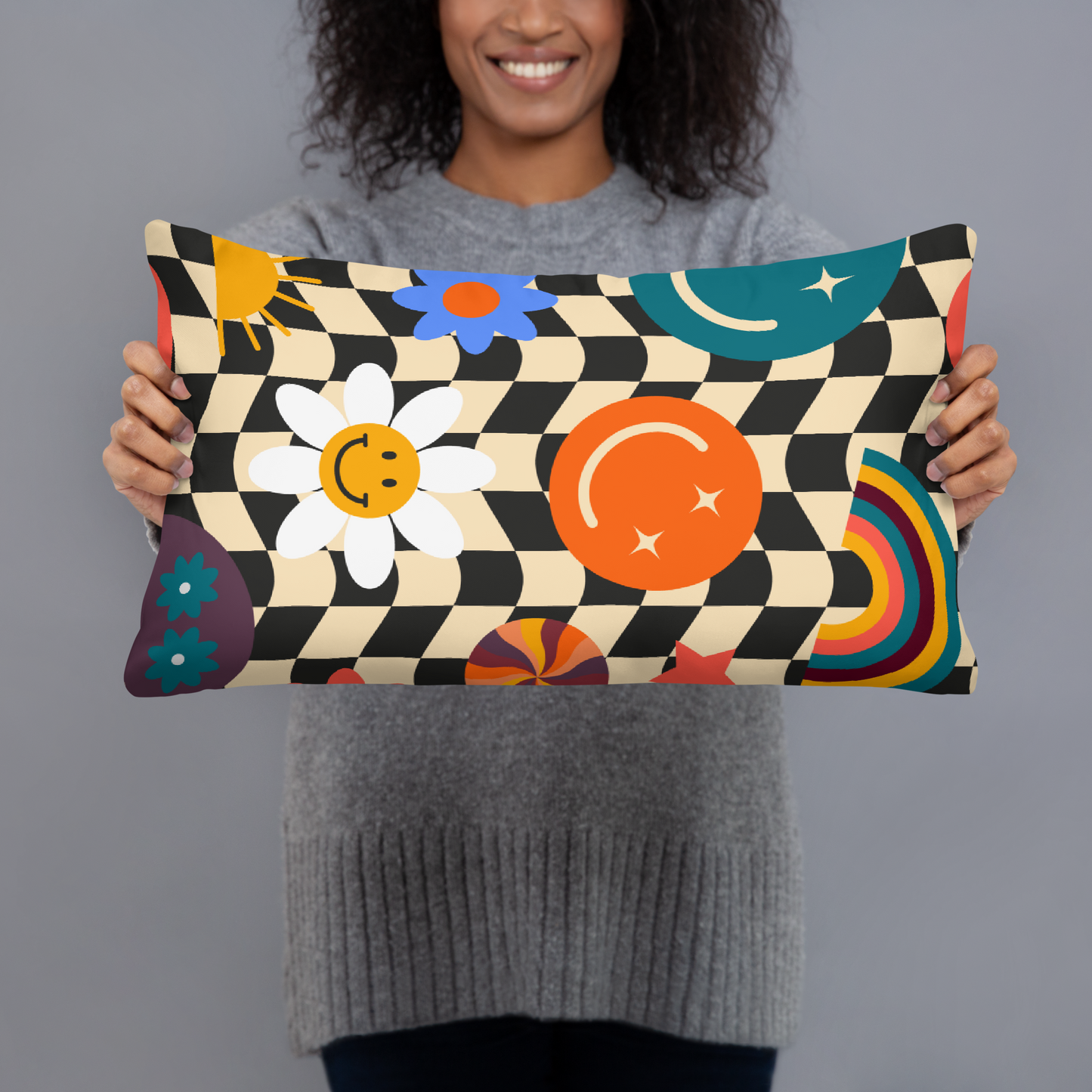 A smiling woman holding a rectangular Y2K smiley face checkerboard throw pillow, showing scale and how this cute accent cushion works perfectly on beds, chairs and cozy lounge spaces. Retro black and tan check pattern with cheerful smiley icons creates a fun soft girl aesthetic that adds happy personality to teen bedrooms, dorm décor and small apartments. Made to order decorative pillow with double sided printing for stylish trendy room décor and cheerful gifting.