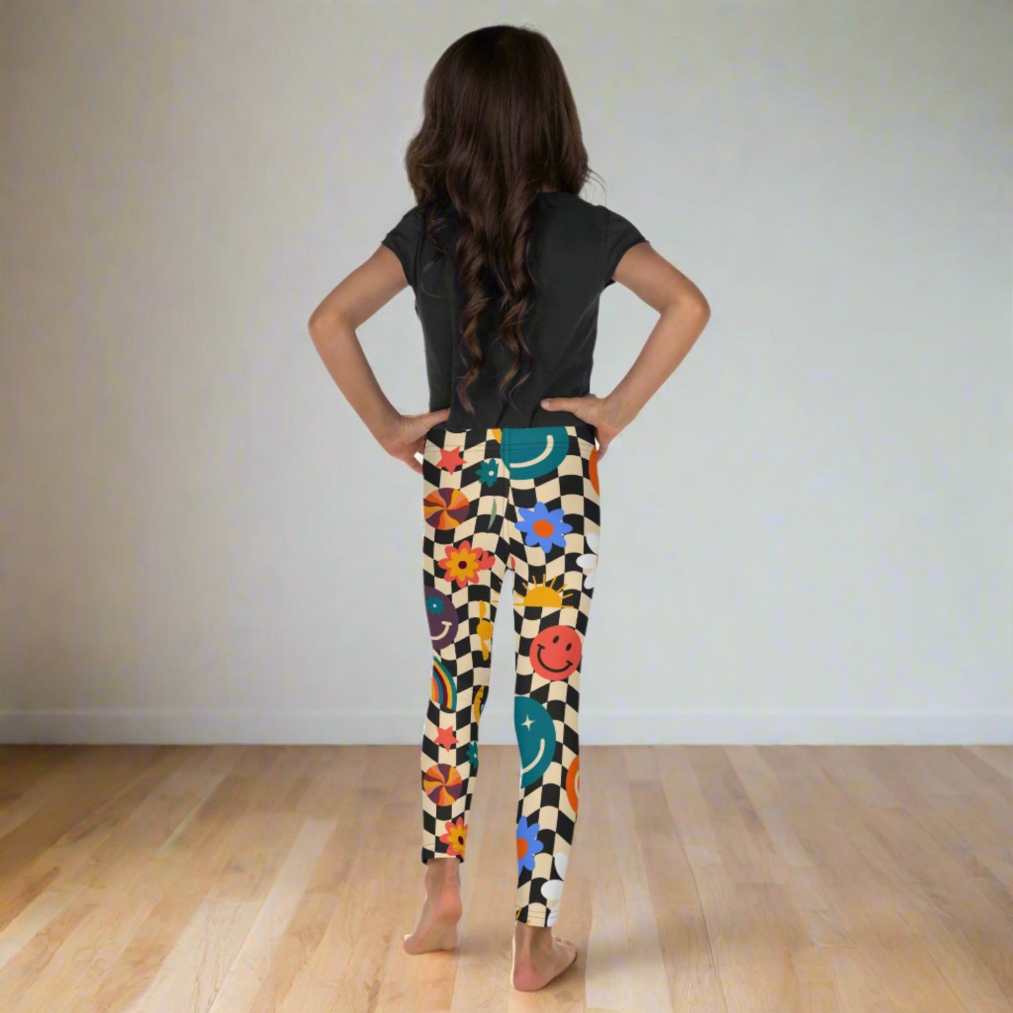 Girls Smiley Face Checkerboard Leggings in sizes 2T–7 bring fun to every outfit with a beige and black wavy checkerboard print decorated with happy faces, rainbows, and daisies. Designed for comfort and movement, these toddler leggings are made with smooth microfiber yarn and vibrant fade-resistant colors. Matching youth and women’s sizes make them a perfect family outfit idea for photos, birthdays, and holidays.