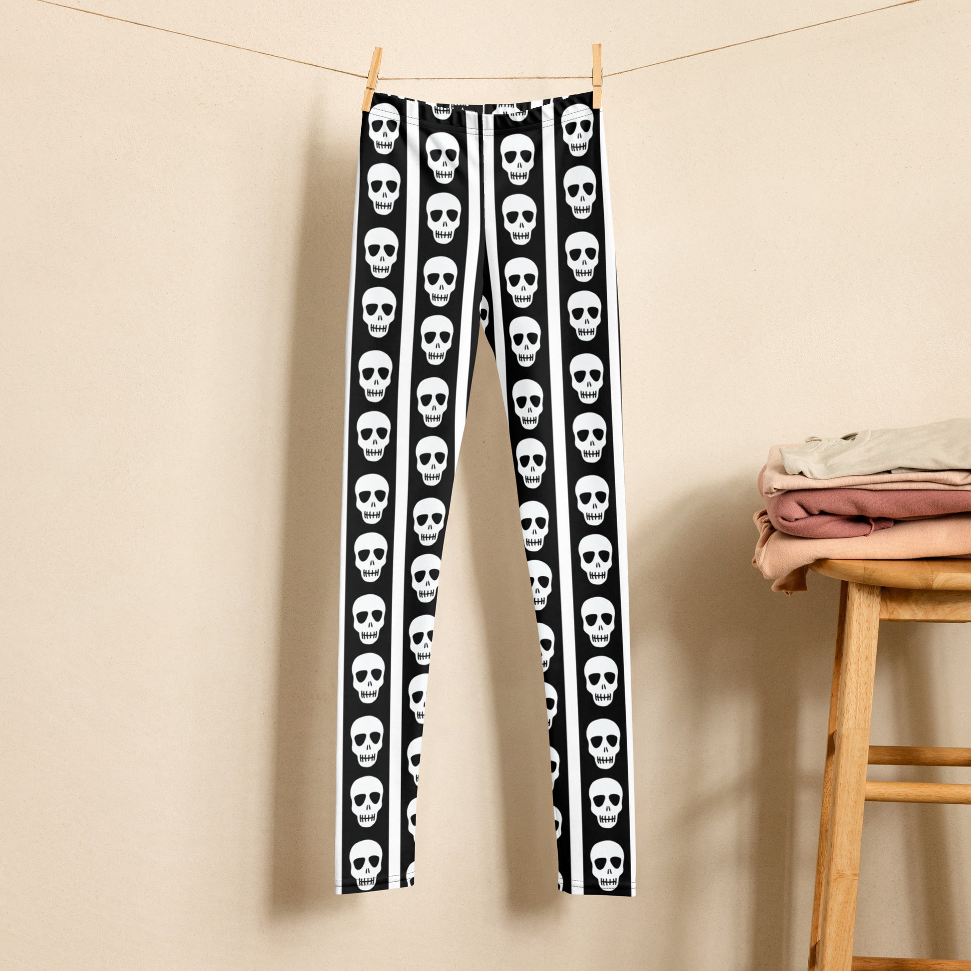 Youth leggings with skull print and vertical stripe pattern in black and white designed for girls and tweens. Sizes 8 to 20 with soft stretchy fabric for everyday comfort and movement. Perfect spooky season leggings for tween Halloween outfits, school days, and fall events. Stylish gothic inspired pants for kids who enjoy edgy fashion, costume looks, and bold statement clothing pieces.