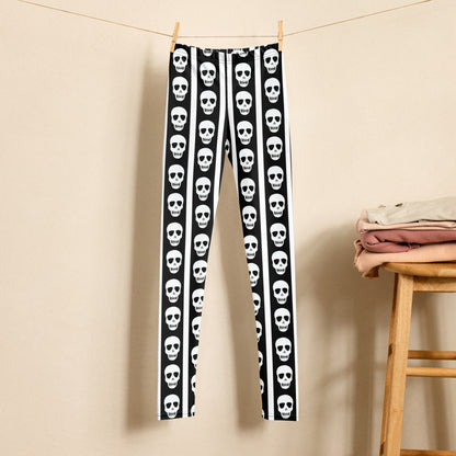 Youth leggings with skull print and vertical stripe pattern in black and white designed for girls and tweens. Sizes 8 to 20 with soft stretchy fabric for everyday comfort and movement. Perfect spooky season leggings for tween Halloween outfits, school days, and fall events. Stylish gothic inspired pants for kids who enjoy edgy fashion, costume looks, and bold statement clothing pieces.