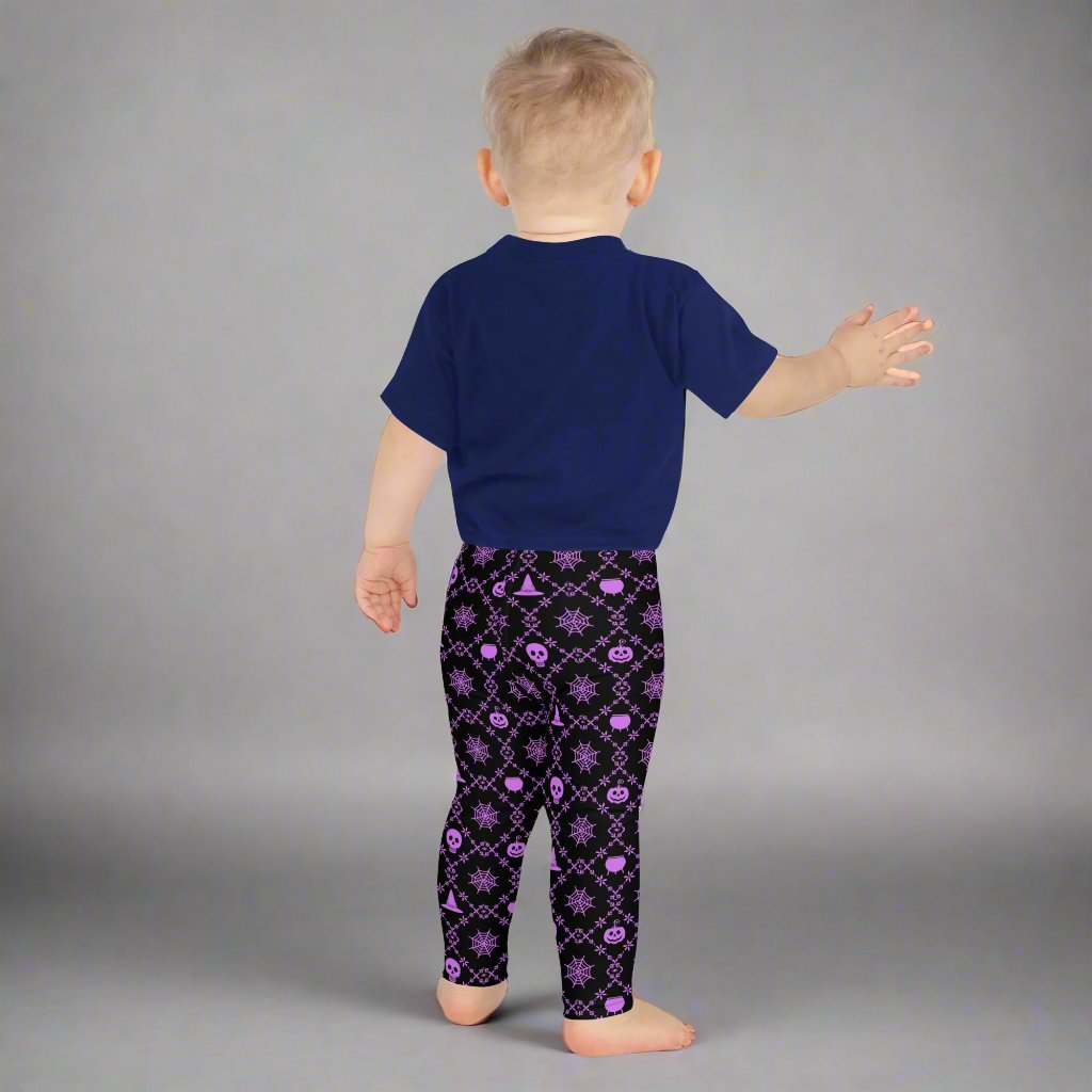 Wickedly Cute Toddler & Kids Halloween Leggings, featuring a black material with a purple geometric pattern that consists of spiders webs, pumpkins, witches hats and skulls, by jaecrece.com