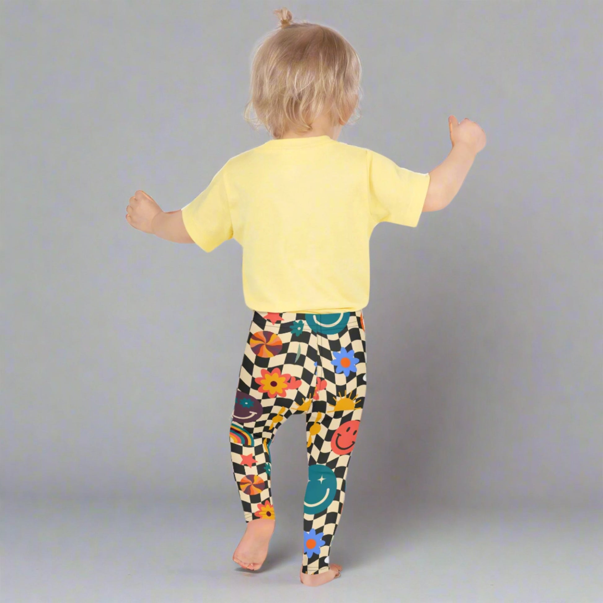 Image: Retro Checkerboard Girls Leggings, in size 2T-7. These toddler and kids yoga pants feature a black and khaki vintage check pattern with smiley faces, daisies, rainbows and suns. These vintage tights make a great birthday present, birthday gift, and are great for back to school, by jaecrece