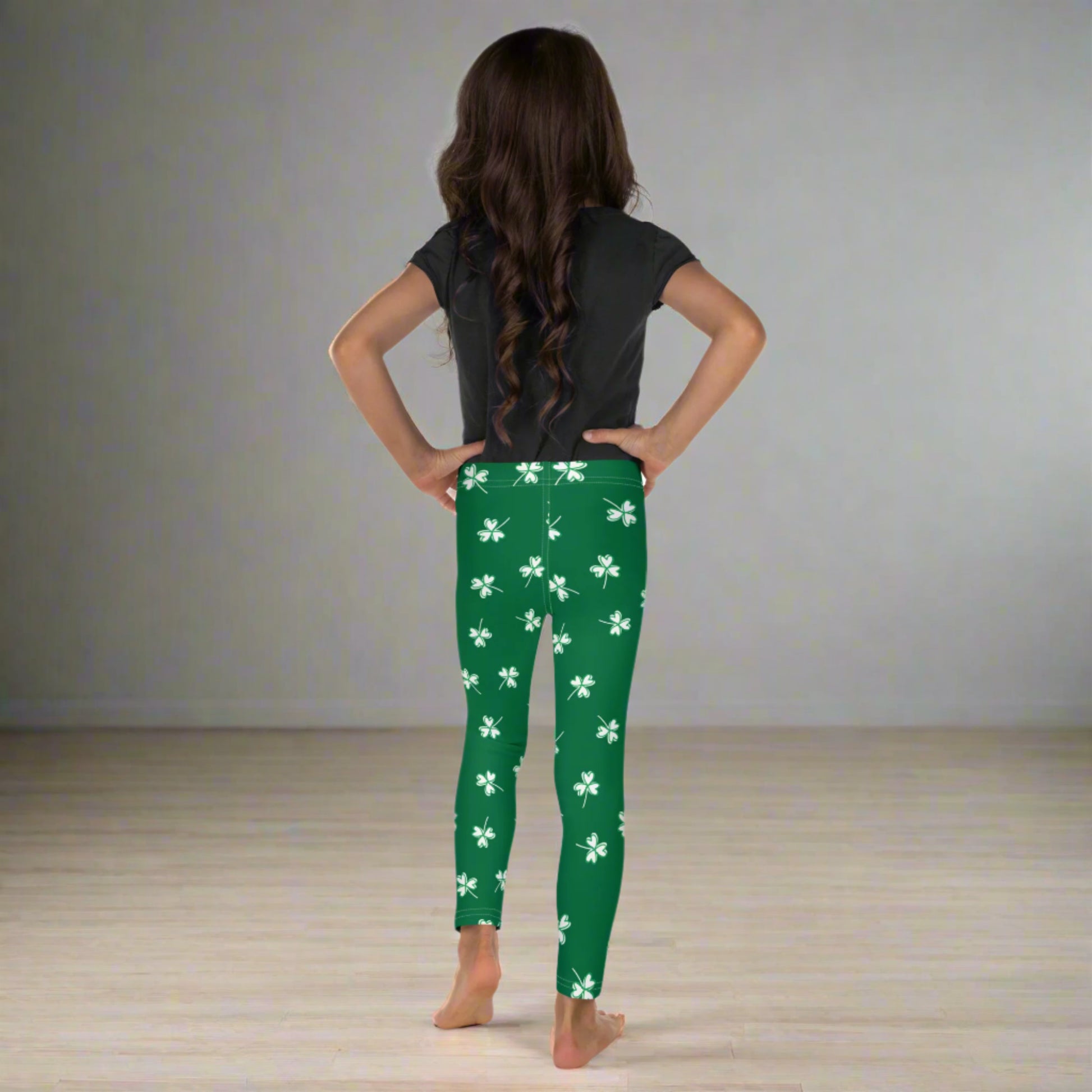 Image: Family Matching St Patricks Day Shamrock Leggings. Festive yoga pants with green background and white four leaf clovers. Available in sizes for toddler girls, teens, tweens, and women. Perfect for a St Pattys Day parade or fun run, by jaecrece