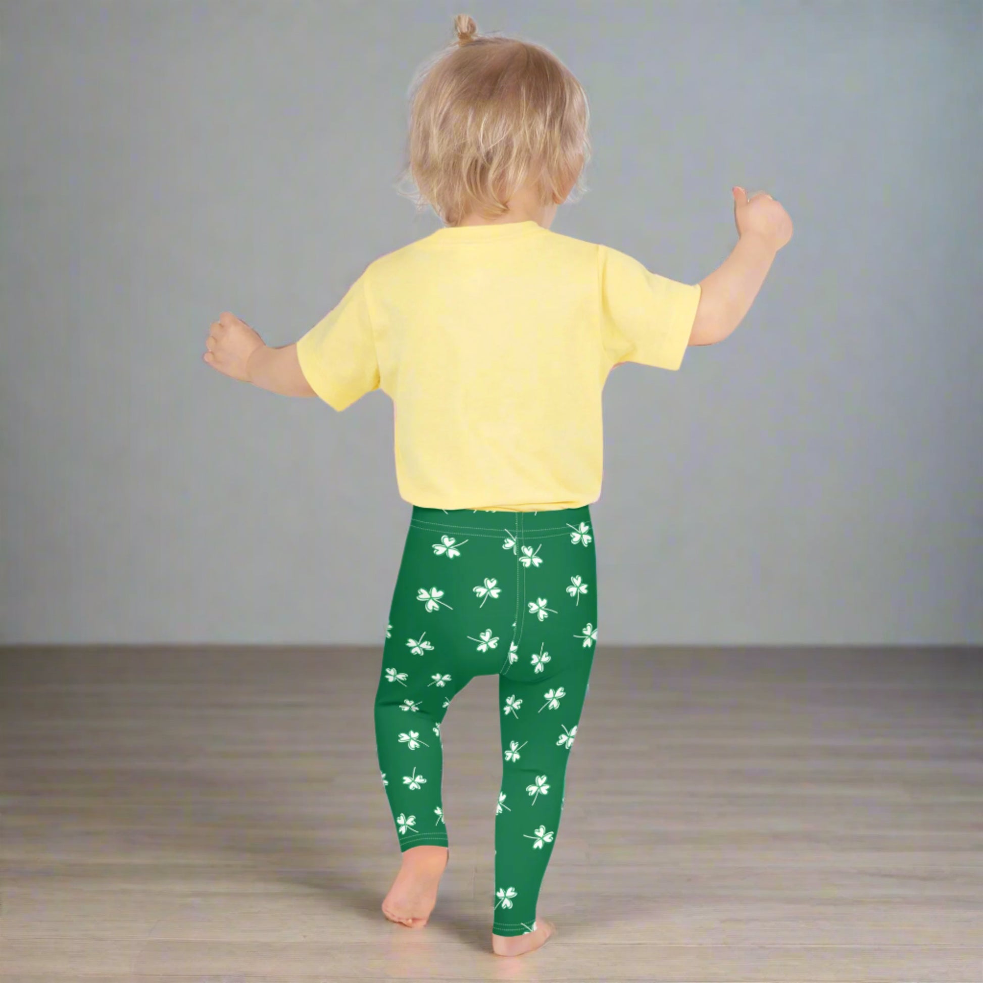 Image: Family Matching St Patricks Day Shamrock Leggings. Festive yoga pants with green background and white four leaf clovers. Available in sizes for toddler girls, teens, tweens, and women. Perfect for a St Pattys Day parade or fun run, by jaecrece