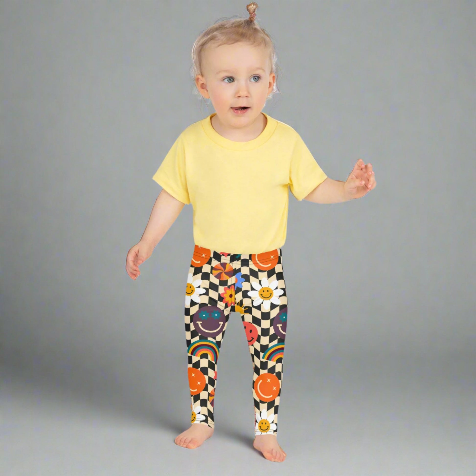 Image: Retro Checkerboard Girls Leggings, in size 2T-7. These toddler and kids yoga pants feature a black and khaki vintage check pattern with smiley faces, daisies, rainbows and suns. These vintage tights make a great birthday present, birthday gift, and are great for back to school, by jaecrece