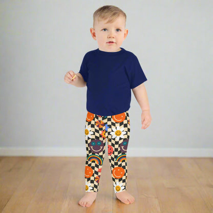 Image: Retro Checkerboard Girls Leggings, in size 2T-7. These toddler and kids yoga pants feature a black and khaki vintage check pattern with smiley faces, daisies, rainbows and suns. These vintage tights make a great birthday present, birthday gift, and are great for back to school, by jaecrece