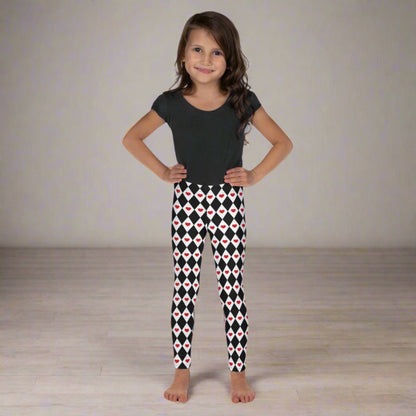 Image: Harlequin Love Girls Leggings in sizes 2T-7. These yoga tights have a black and white checker/ diamond pattern with a red heart accent, the perfect leggings for valentines day or a Queen of Hearts costume, by jaecrece