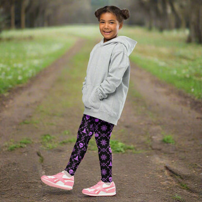 Wickedly Cute Toddler & Kids Halloween Leggings, featuring a black material with a purple geometric pattern that consists of spiders webs, pumpkins, witches hats and skulls, by jaecrece.com