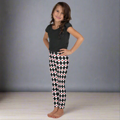 Image: Harlequin Love Girls Leggings in sizes 2T-7. These yoga tights have a black and white checker/ diamond pattern with a red heart accent, the perfect leggings for valentines day or a Queen of Hearts costume, by jaecrece