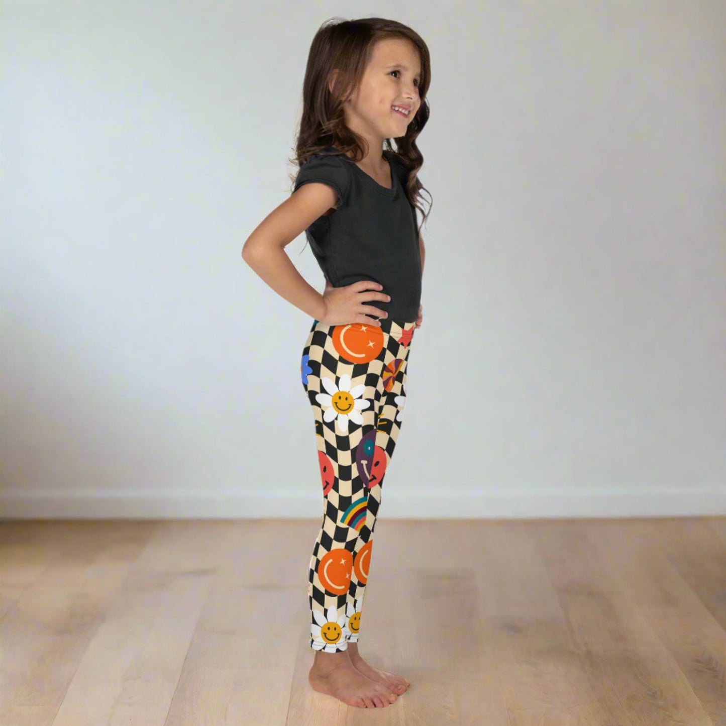 Image: Retro Checkerboard Girls Leggings, in size 2T-7. These toddler and kids yoga pants feature a black and khaki vintage check pattern with smiley faces, daisies, rainbows and suns. These vintage tights make a great birthday present, birthday gift, and are great for back to school, by jaecrece