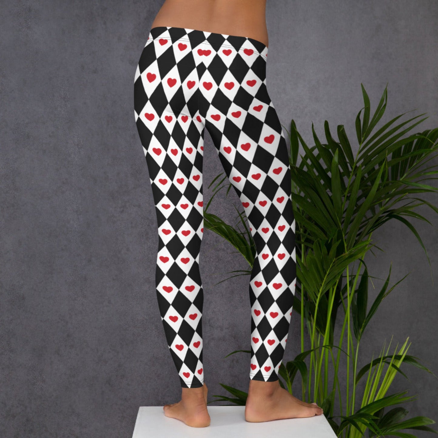 Image: Harlequin Love Ladies Leggings. These yoga tights have a black and white checker/ diamond pattern with a red heart accent, the perfect leggings for valentines day or a Queen of Hearts costume, by jaecrece