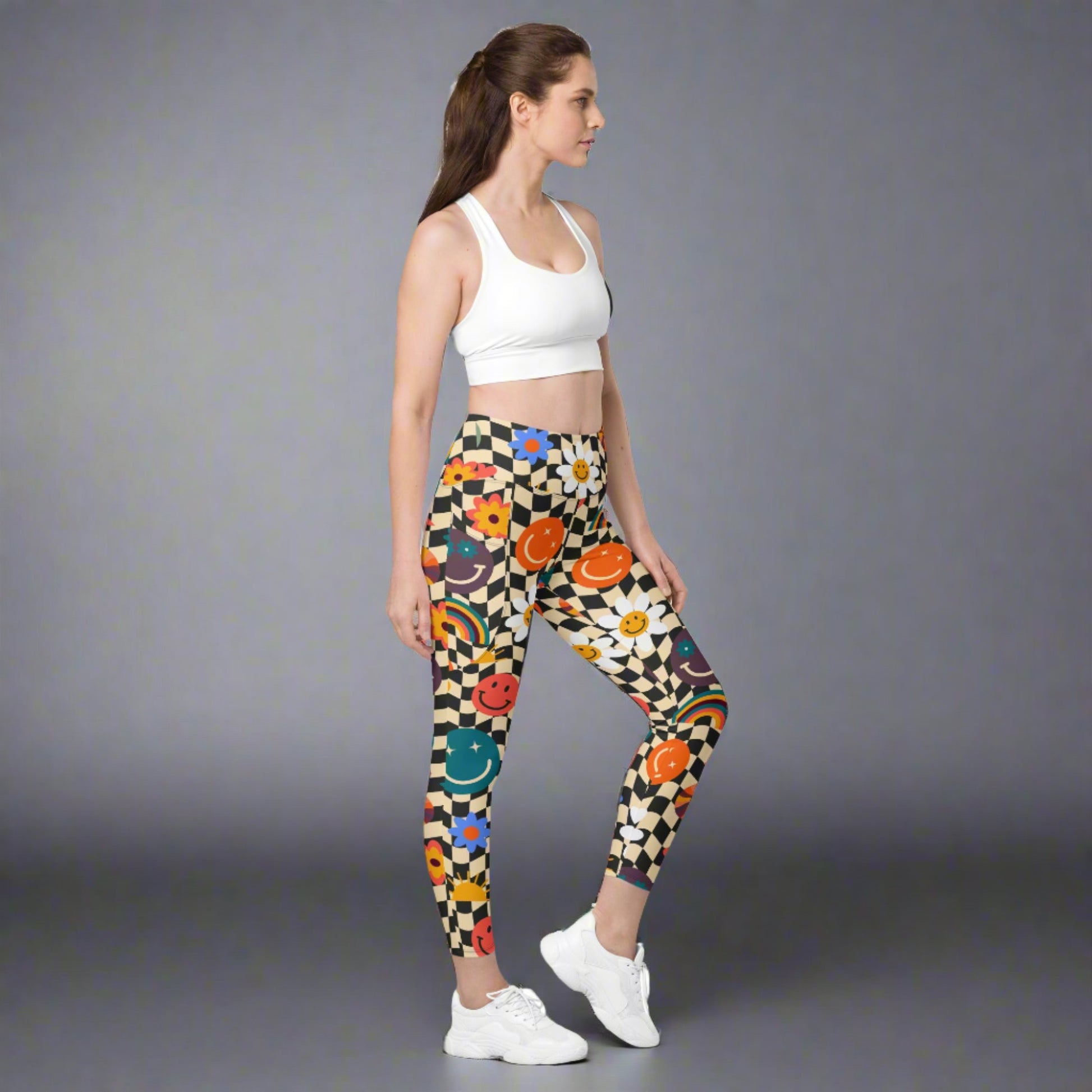 Smiley Face Checkerboard Adult Leggings. These cute retro leggings feature a black and khaki checkerboard background, with smiley face, rainbow and daisy graphics. In adult ladies sizes. by jaecrece.com - jaecrece