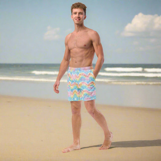 Man on the beach, wearing the pastel tie dye recycled mens swim trunks, by jaecrece.com