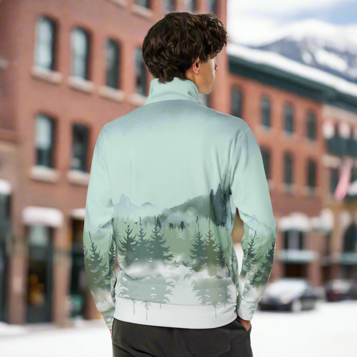 Image: Winter Forest Unisex Track Jacket. This nature inspired workout jacket has an ombre snowy mountain print that fades from a blue gray sky to mountains and pine trees to white snow. Suitable for men and women, by jaecrece