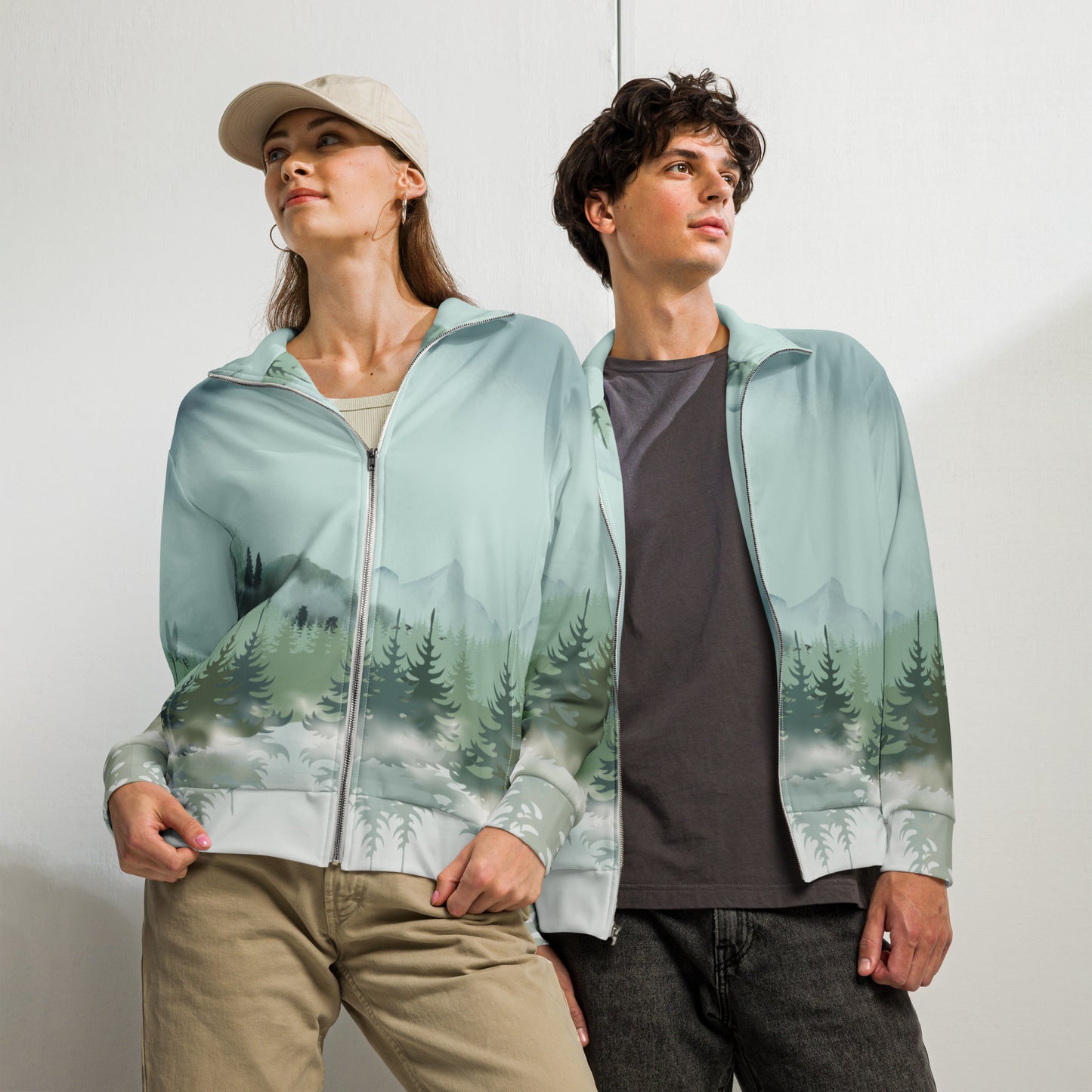 Image: Winter Forest Unisex Track Jacket. This nature inspired workout jacket has an ombre snowy mountain print that fades from a blue gray sky to mountains and pine trees to white snow. Suitable for men and women, by jaecrece