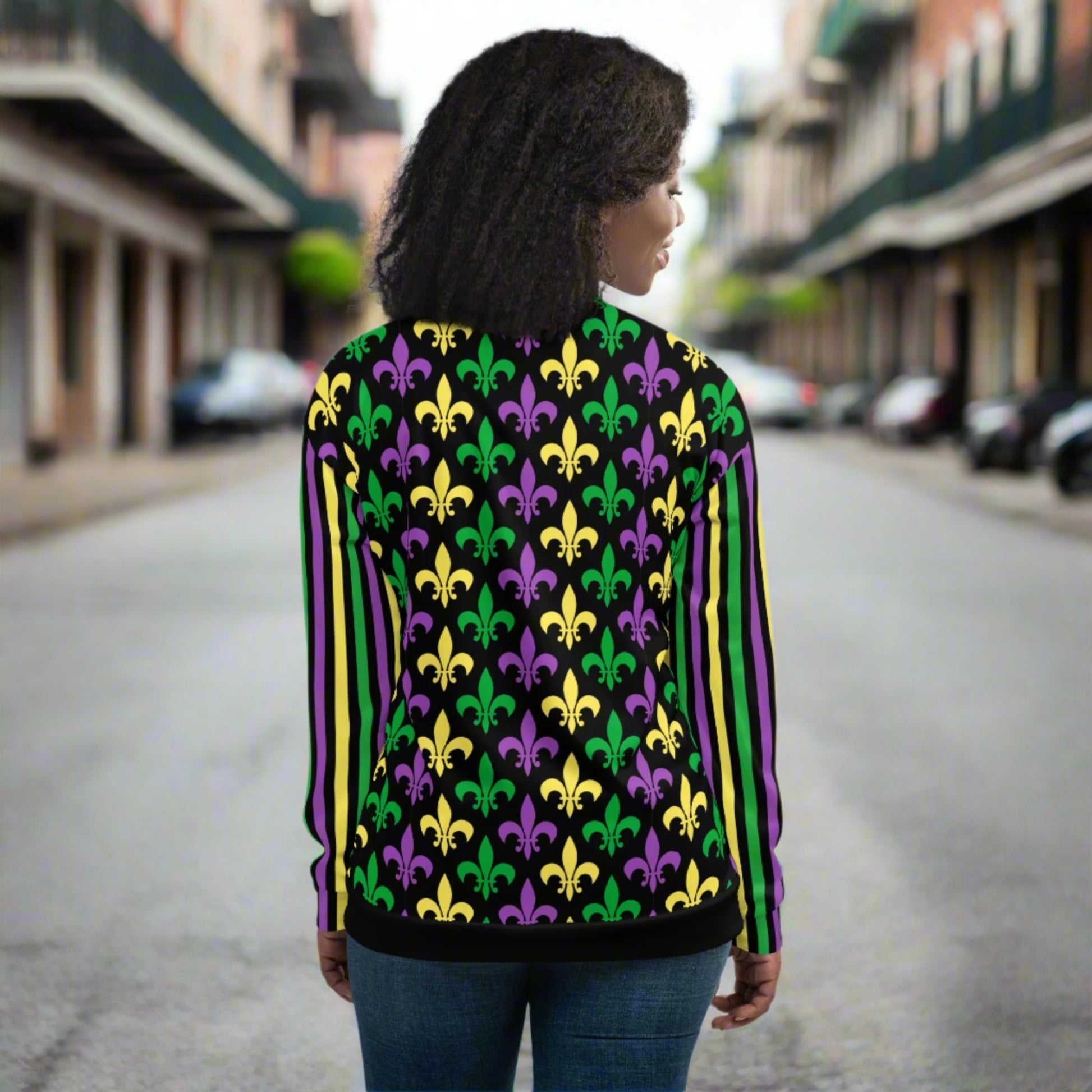 Image: Mardi Gras Unisex Bomber Jacket. This lightweight NOLA apparel is perfect for parades in the French Quarter, or Mardi Gras themed fun runs. It features a gold, green and purple fleur de lis pattern on the front and back, with gold, purple and green stripes going down each arm. Plus sizes available, by jaecrece