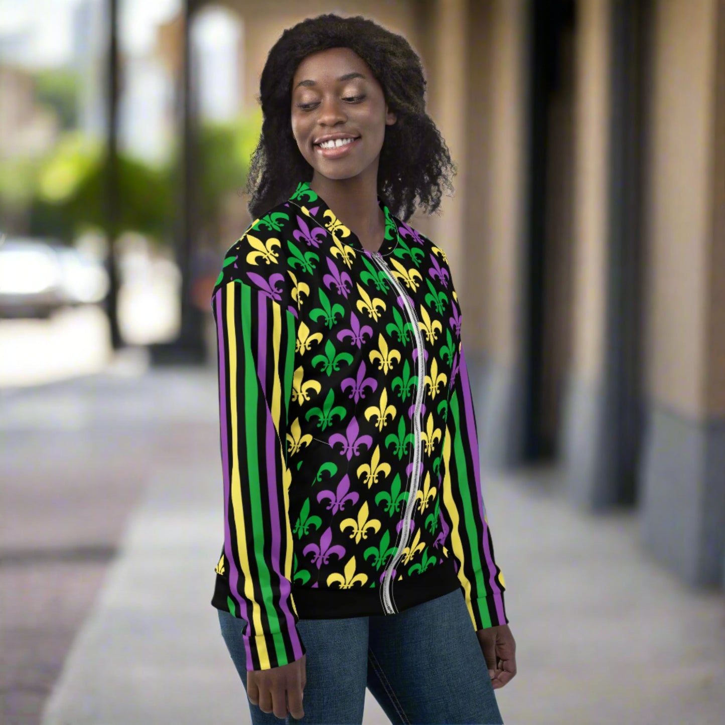 Image: Mardi Gras Unisex Bomber Jacket. This lightweight NOLA apparel is perfect for parades in the French Quarter, or Mardi Gras themed fun runs. It features a gold, green and purple fleur de lis pattern on the front and back, with gold, purple and green stripes going down each arm. Plus sizes available, by jaecrece