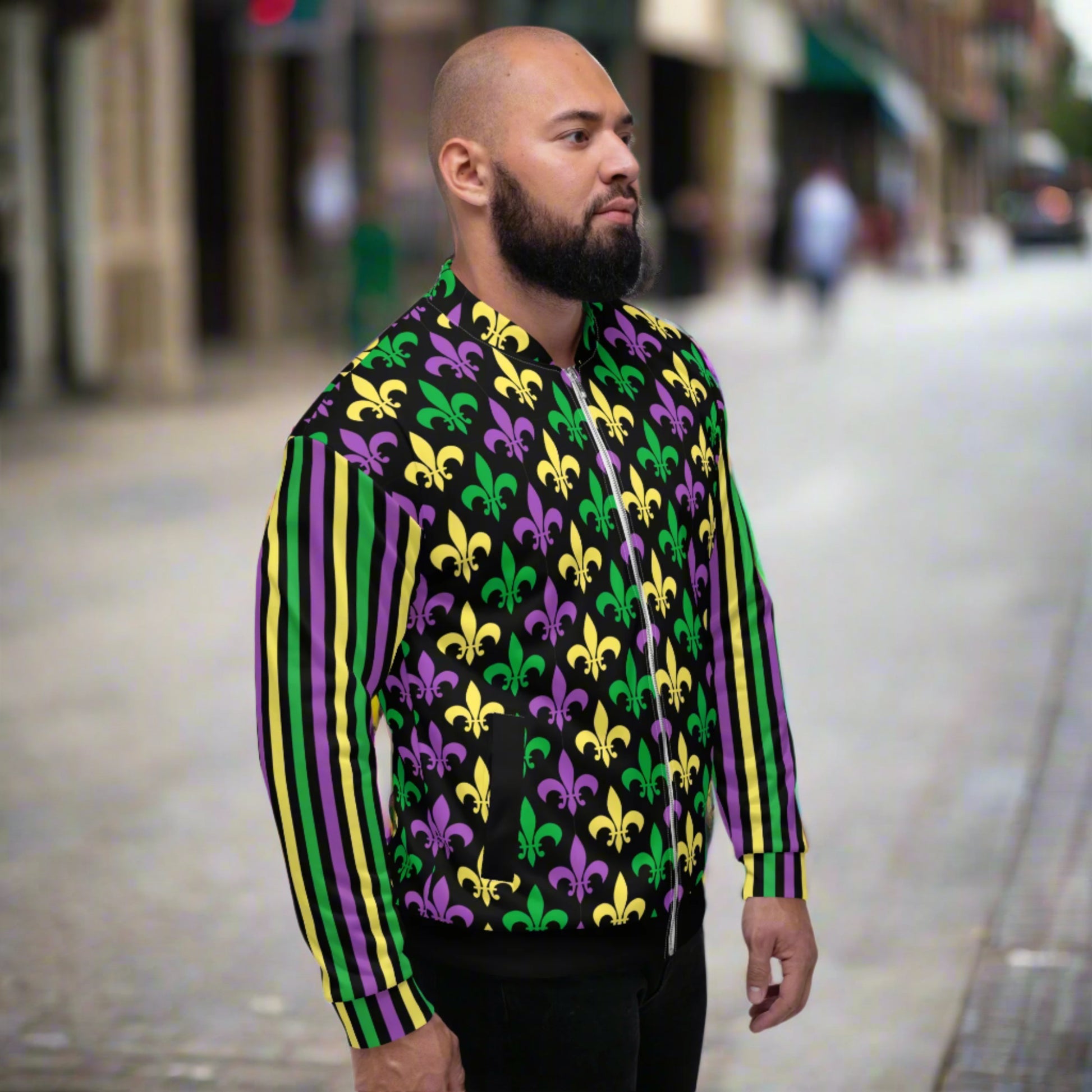 Image: Mardi Gras Unisex Bomber Jacket. This lightweight NOLA apparel is perfect for parades in the French Quarter, or Mardi Gras themed fun runs. It features a gold, green and purple fleur de lis pattern on the front and back, with gold, purple and green stripes going down each arm. Plus sizes available, by jaecrece