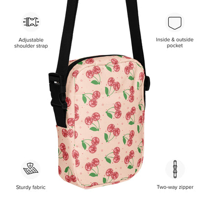 Image: Pink Utility Crossbody bag with a pattern of red disco ball cherries and stars. A great small tote to be worn across the chest, hips, waist. Perfect  as a Valentines Day gift or for outdoor activities, such as parades, hiking or the amusement park, by jaecrece