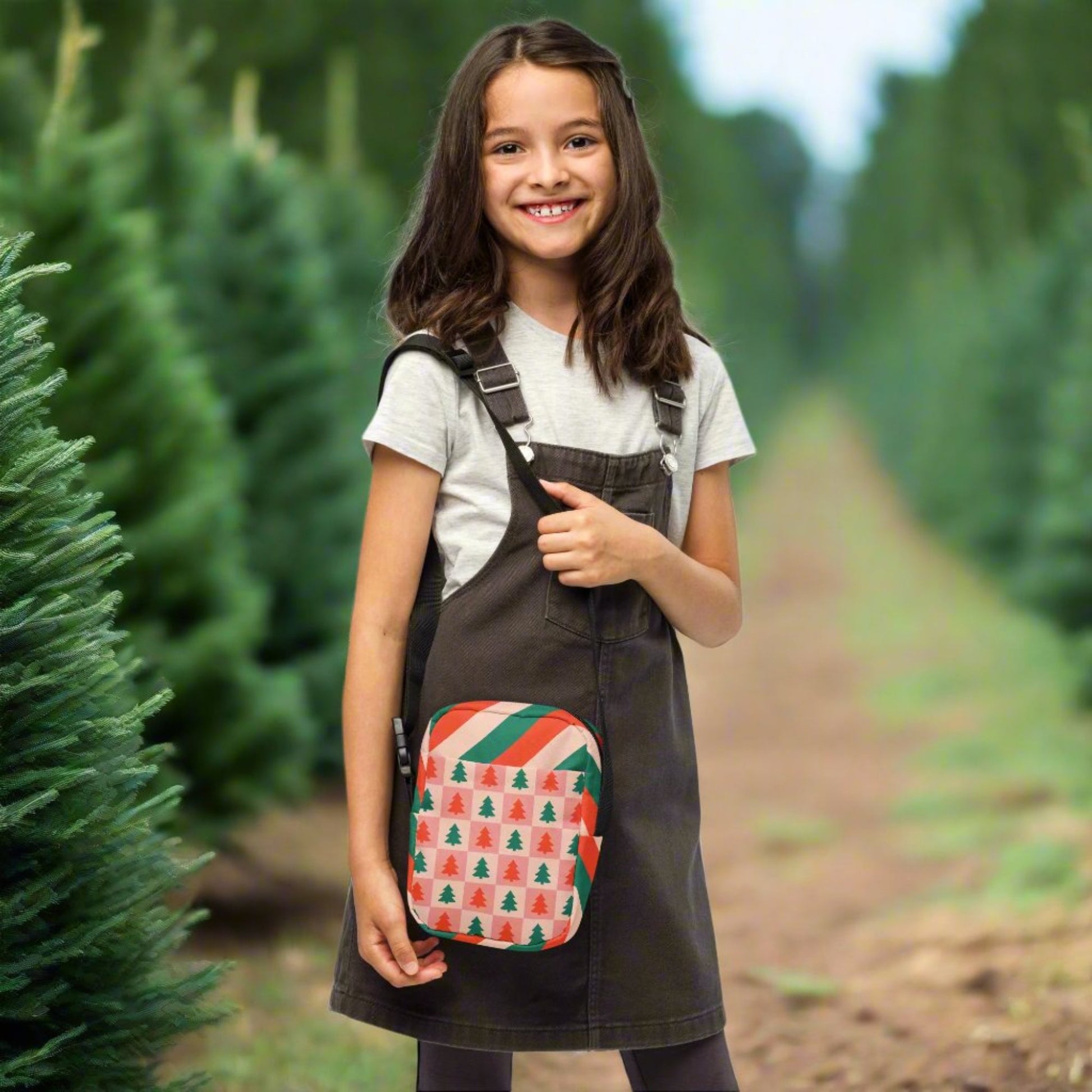 Our red and pink christmas tree utility crossbody bag has a pink and red checker pattern with xmas trees on the front and back. The sides of this small canvas tote are red, pink and green candy cane stripes. This mini backpack is perfect for parades, hiking, biking or anywhere you need to be hands free. Makes a great holiday gift for girls, moms, teens or tweens, by jaecrece