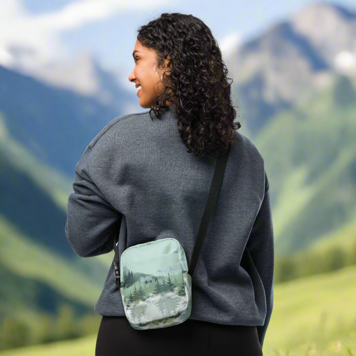 Image: Winter Forest Small Cross Body Bag. This nature inspired sling bag has an ombre snowy mountain print that fades from a blue gray sky to mountains and pine trees to white snow. This mini backpack has a zipper closure and two storage pockets for hands free outdoor adventures. Great for tween girls, teens and ladies, by jaecrece