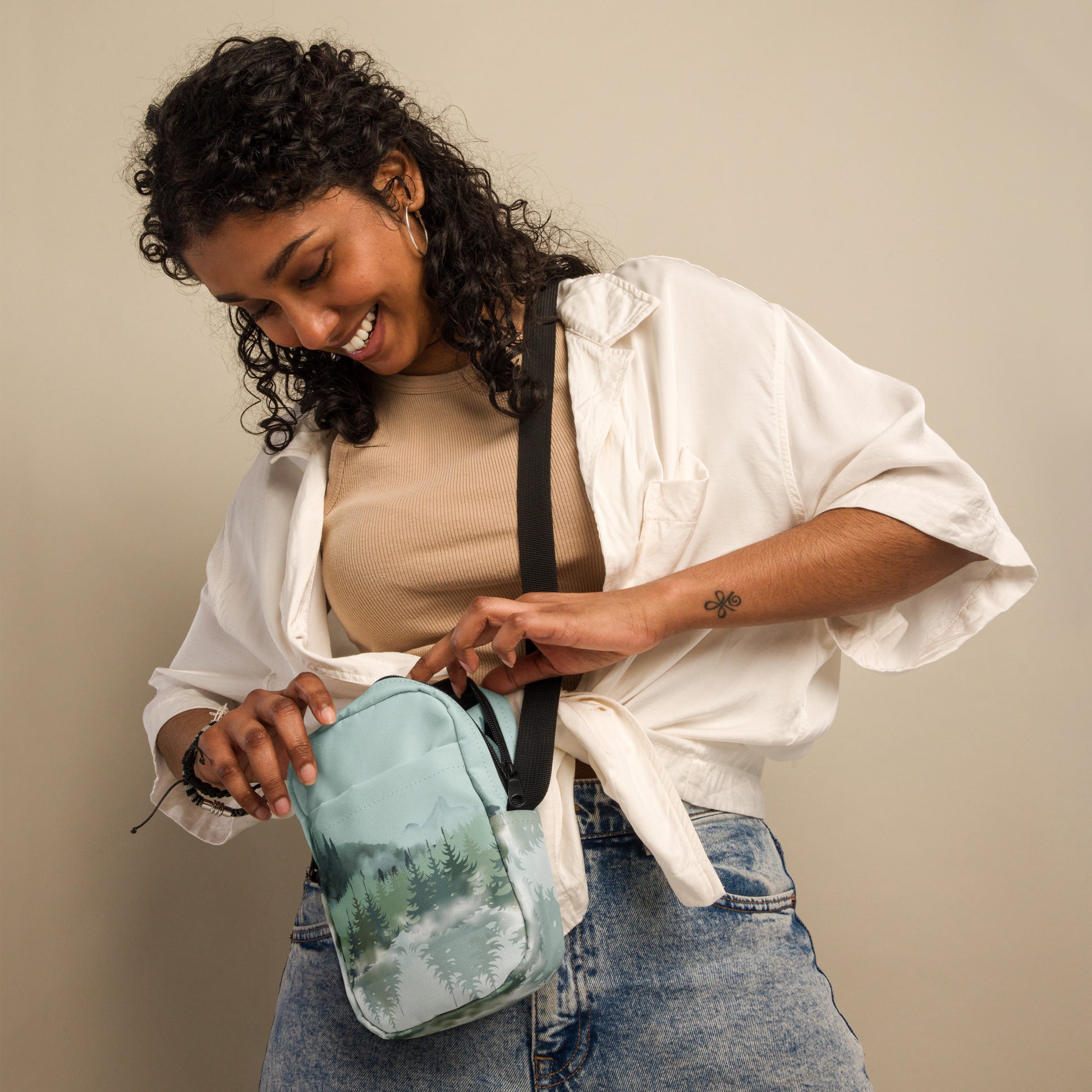 Image: Winter Forest Small Cross Body Bag. This nature inspired sling bag has an ombre snowy mountain print that fades from a blue gray sky to mountains and pine trees to white snow. This mini backpack has a zipper closure and two storage pockets for hands free outdoor adventures. Great for tween girls, teens and ladies, by jaecrece