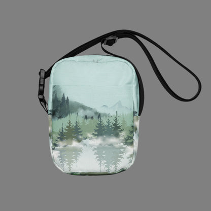 Image: Winter Forest Small Cross Body Bag. This nature inspired sling bag has an ombre snowy mountain print that fades from a blue gray sky to mountains and pine trees to white snow. This mini backpack has a zipper closure and two storage pockets for hands free outdoor adventures. Great for tween girls, teens and ladies, by jaecrece