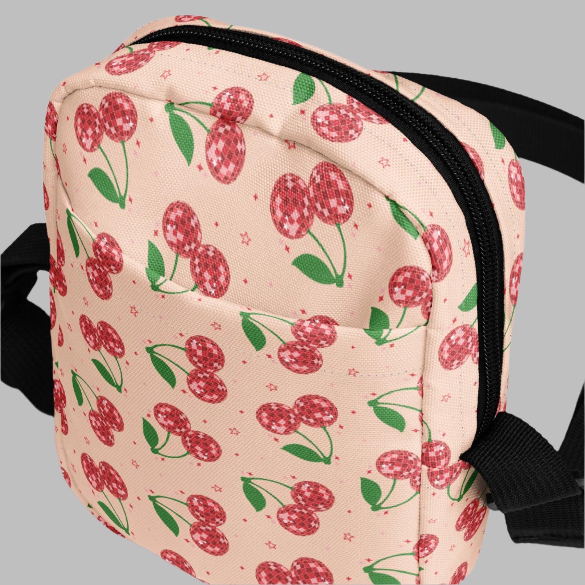 Image: Pink Utility Crossbody bag with a pattern of red disco ball cherries and stars. A great small tote to be worn across the chest, hips, waist. Perfect  as a Valentines Day gift or for outdoor activities, such as parades, hiking or the amusement park, by jaecrece