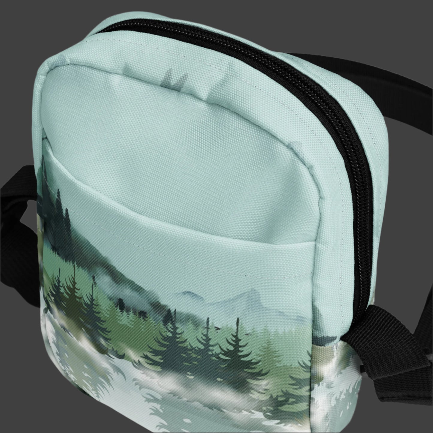 Image: Winter Forest Small Cross Body Bag. This nature inspired sling bag has an ombre snowy mountain print that fades from a blue gray sky to mountains and pine trees to white snow. This mini backpack has a zipper closure and two storage pockets for hands free outdoor adventures. Great for tween girls, teens and ladies, by jaecrece