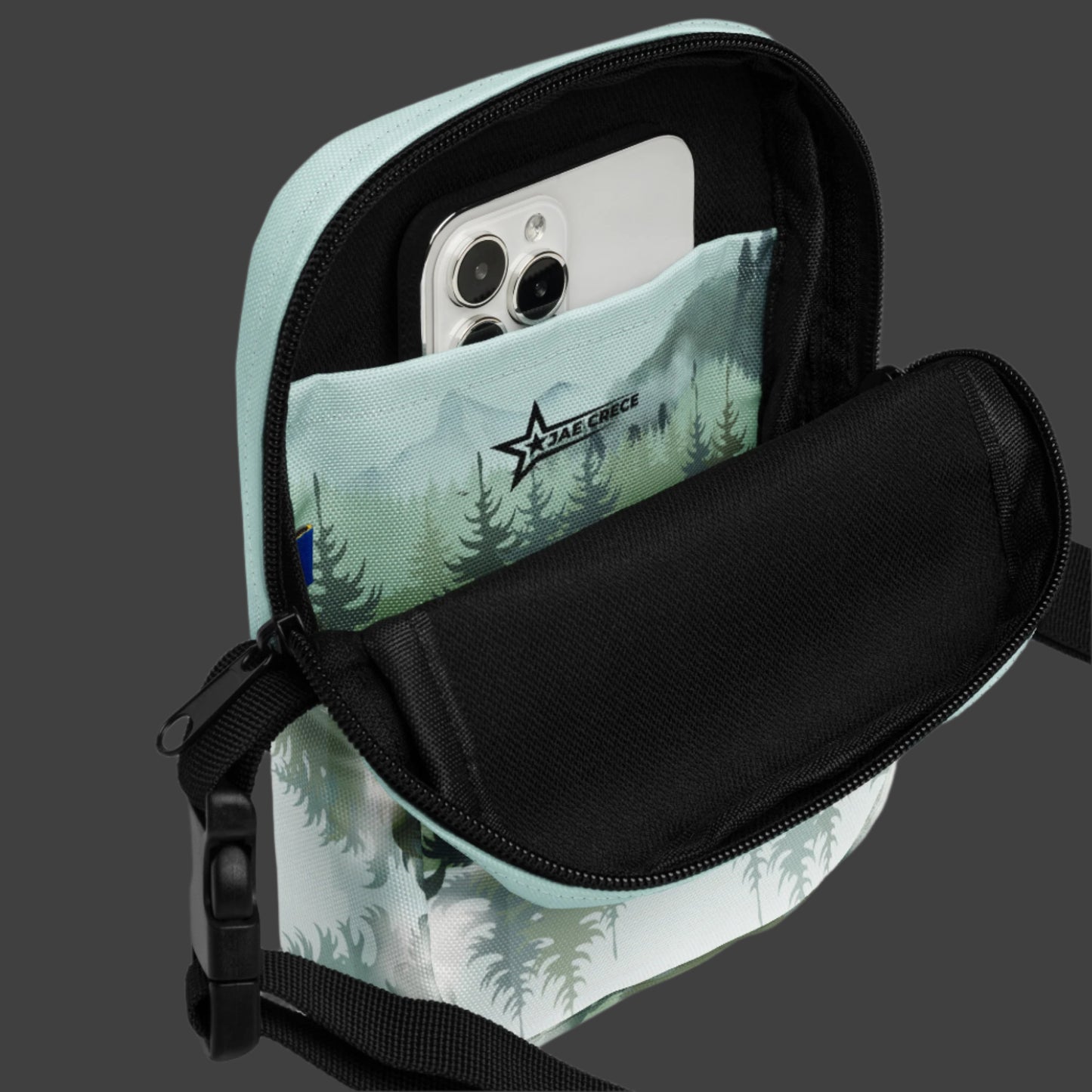 Image: Winter Forest Small Cross Body Bag. This nature inspired sling bag has an ombre snowy mountain print that fades from a blue gray sky to mountains and pine trees to white snow. This mini backpack has a zipper closure and two storage pockets for hands free outdoor adventures. Great for tween girls, teens and ladies, by jaecrece