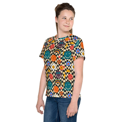 Smiley Face Checkerboard Youth Shirt, size 8-20. This cute retro shirt features a black and khaki checkerboard background, with smiley face, rainbow and daisy graphics. In tween and teen sizes. by jaecrece.com