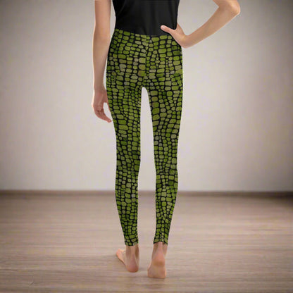 Reptile print youth girls leggings, size 8-20. These green yoga pants have a black reptile print pattern. These tights are available in plus/ extended sizes, and are perfect for casual wear, cosplay, Halloween Trick or treating or yoga class. Similar to a snake, lizard or dinosaur print, by jaecrece