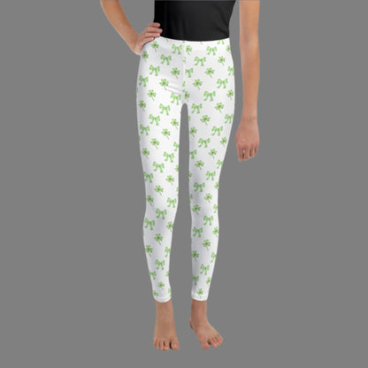 Image: St Patricks Day Leggings for toddlers, girls, tween and women. These white coquette yoga pants feature a dainty pattern of shamrocks and bows, by jaecrece