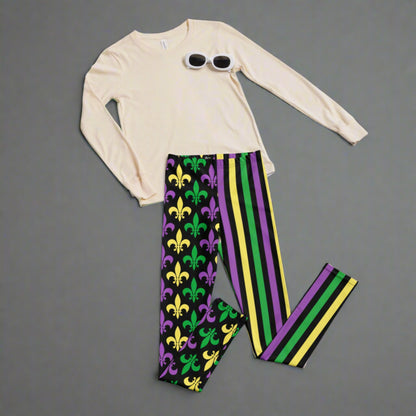 Alt text: "Mardi Gras Stripes and Fleur de Lis Youth Leggings, size 8-20. Black leggings with a fleur de lis pattern on one leg and bright green, purple, and yellow stripes on the other. Elastic, soft, and durable with vibrant colors. Part of a matching collection for younger children and women, each pair is precision-cut and hand-sewn for a perfect fit."