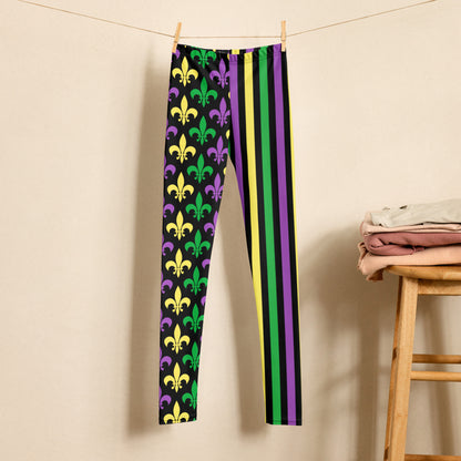 Alt text: "Mardi Gras Stripes and Fleur de Lis Youth Leggings, size 8-20. Black leggings with a fleur de lis pattern on one leg and bright green, purple, and yellow stripes on the other. Elastic, soft, and durable with vibrant colors. Part of a matching collection for younger children and women, each pair is precision-cut and hand-sewn for a perfect fit."