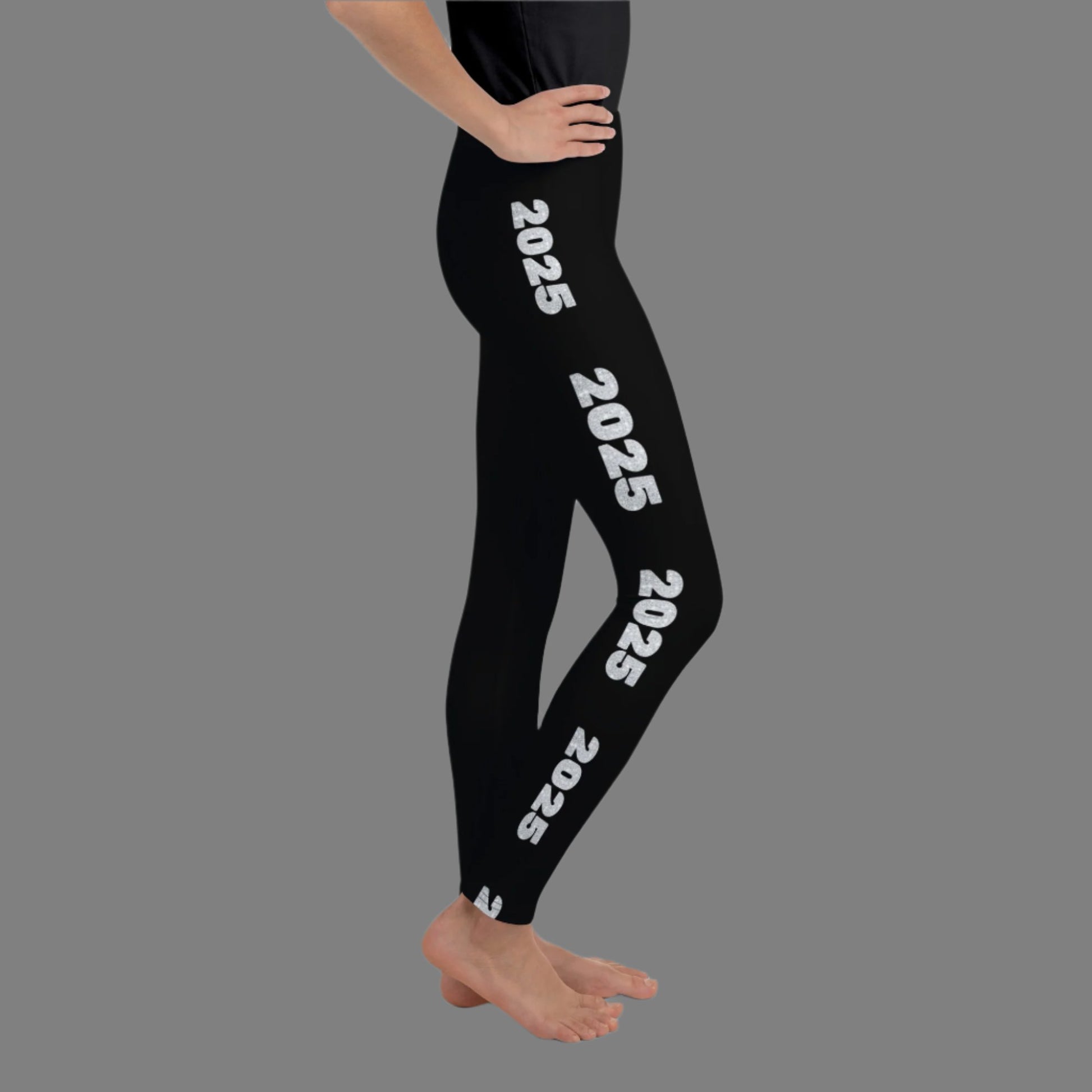 2025 Leggings for Happy New Year Party Celebration or a gift for graduating class of 2025. Black yoga pants have large repeating silver 2025 running down the outside of each leg. Tights are available in youth, tween, teen sizes 8-20, by jaecrece