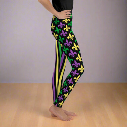 Alt text: "Mardi Gras Stripes and Fleur de Lis Youth Leggings, size 8-20. Black leggings with a fleur de lis pattern on one leg and bright green, purple, and yellow stripes on the other. Elastic, soft, and durable with vibrant colors. Part of a matching collection for younger children and women, each pair is precision-cut and hand-sewn for a perfect fit."