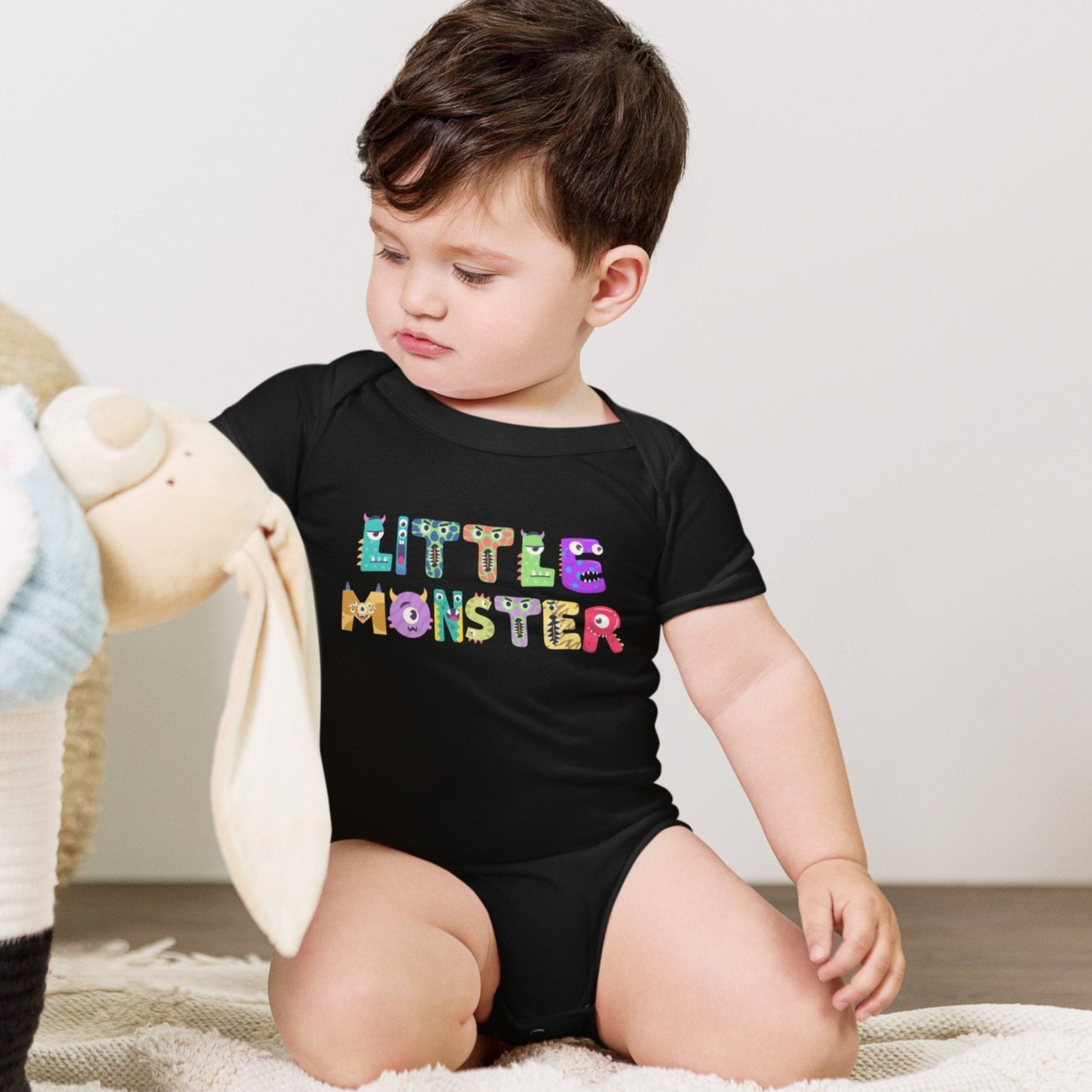 Baby onesie available in black or white. Features the words Little Monster, and each letter is in the shape of a cute cartoon monster, by jaecrece