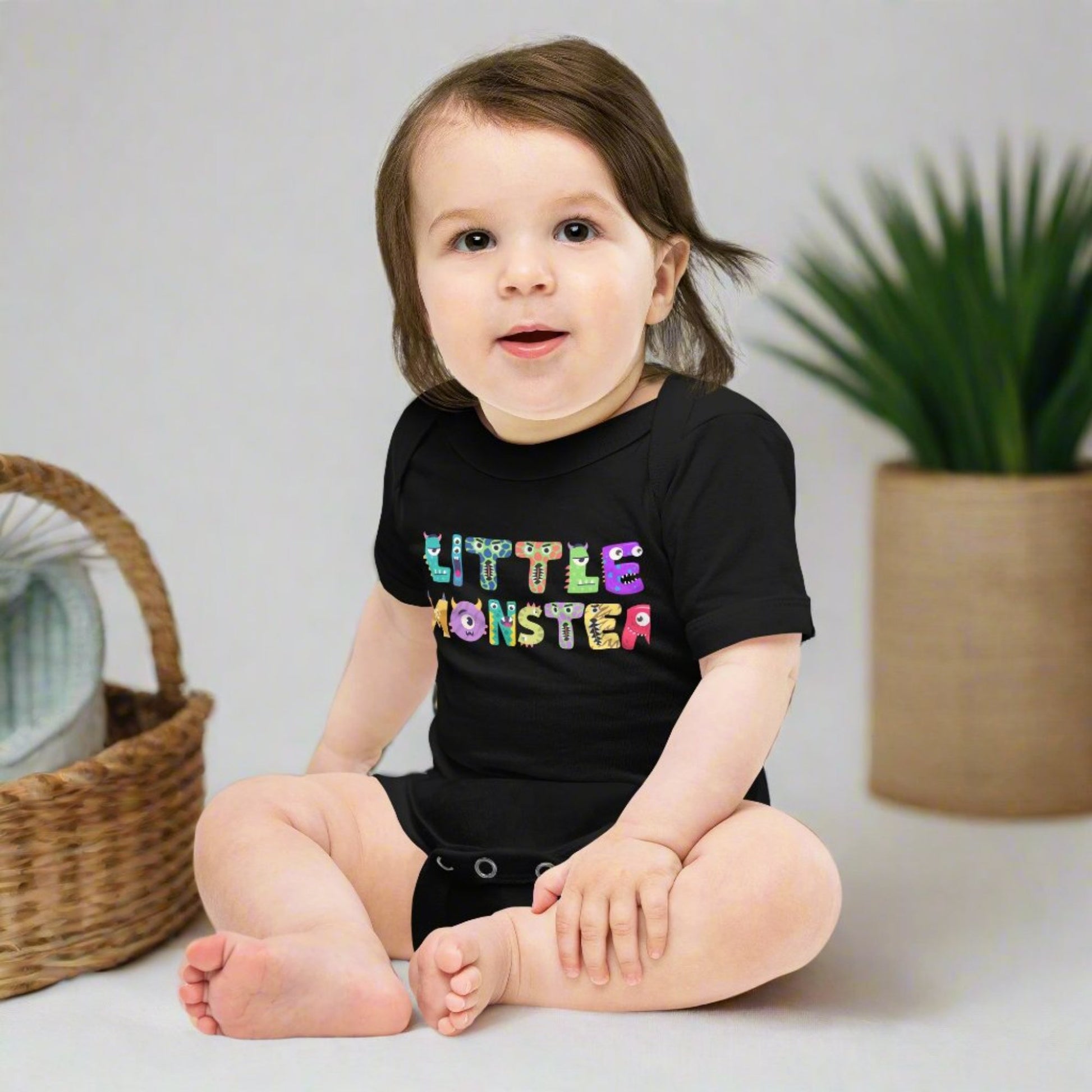 Baby onesie available in black or white. Features the words Little Monster, and each letter is in the shape of a cute cartoon monster, by jaecrece