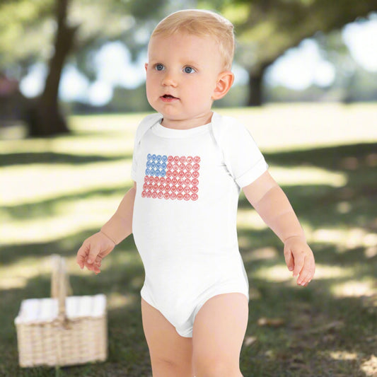 White baby bodysuit onesie. The graphic is an American flag, made up of Blue and Red Vintage smiley faces, by jaecrece.com