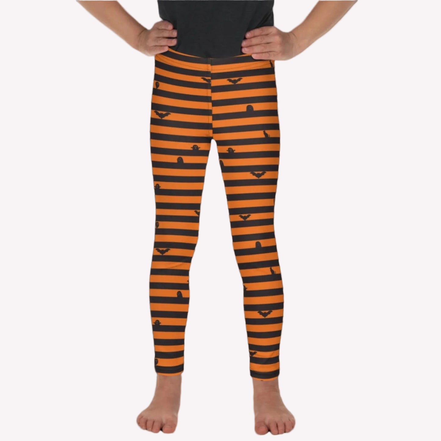 Little Girl wearing black and orange Halloween striped leggings featuring bats, cats, and ghosts for a cute spooky season outfit