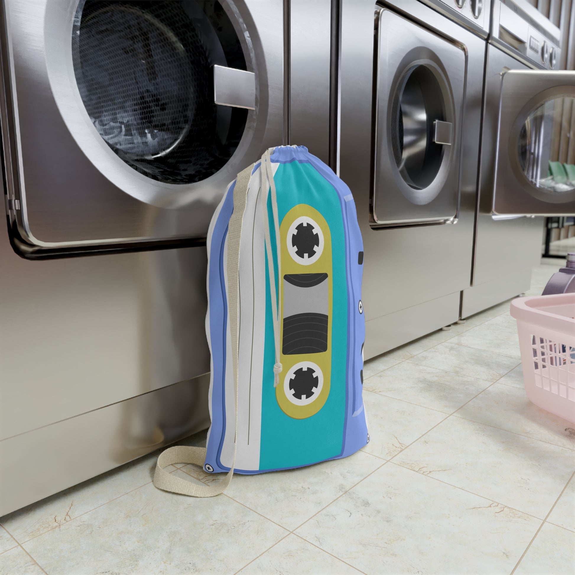 Blue personalized laundry bag covered in colorful cassette tape artwork with a custom name incorporated into the design. The spacious 18 x 29 inch bag features a woven carrying strap and gathered drawstring closure. Retro inspired artwork gives the laundry sack a playful music themed appearance. Ideal for storing clothing, linens, towels, camp gear, and travel essentials while bringing personality and organization to any space.