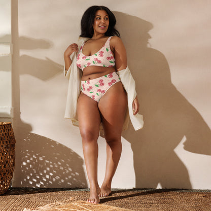 Soft blush pink fabric covered with sparkling cherry graphics gives this women's bikini a fun retro aesthetic. The flattering high waisted bottoms pair with a scoop neck bikini top that includes removable pads and durable construction for active summer adventures. Offered in sizes Small through 3XL, this recycled swimsuit is part of a matching family swim collection and makes a wonderful gift for birthdays, bridal parties, or vacations.