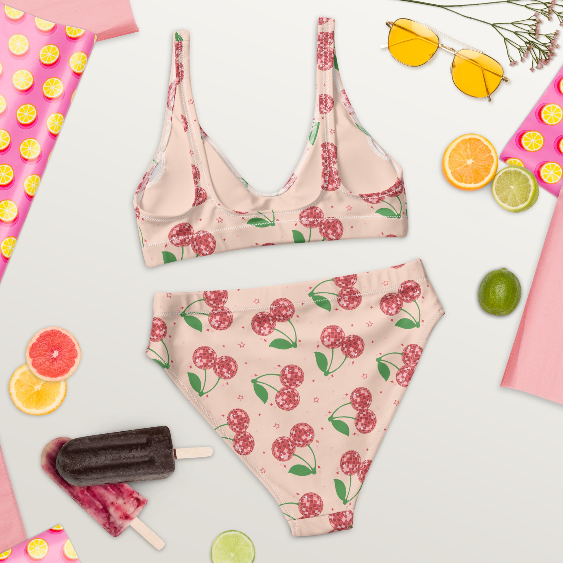 A fashionable women's bikini showcasing a unique disco cherry pattern with vintage inspired details and a sweet coquette aesthetic. The high waisted bottoms provide flattering coverage while the soft recycled fabric stretches comfortably for swimming and lounging. Available in sizes Small through 3XL, this bikini coordinates with matching swimwear for girls and men, making it perfect for family vacations, cruises, and beach portraits.